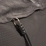 Cartera negra con doble asa de hombro y correa larga extraíble. La parte superior es de cuero sintético arrugado y la parte inferior es de tela con textura de pequeños rombos.