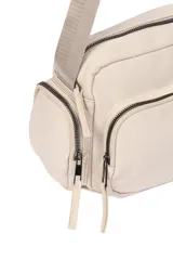 Bandolera color crudo con correa ajustable, bolsillo frontal con cierre y bolsillos laterales con cierre.