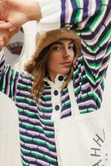 Sweater oversize de punto con rayas horizontales en colores azul, verde y lila. Tiene cuello polo blanco con cartera de botones.