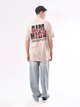 Remera beige de corte recto con estampado 'Aim High' en el pecho.