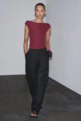 Body negro de poliamida con cuello barco, manga corta y cierre con broches a presión en la parte inferior.