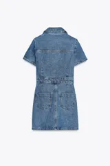 Vestido corto de denim azul, con cuello solapa, escote en pico, manga corta, bolsillos delanteros y cierre frontal con botones metálicos.