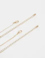 Collar corto dorado de doble cadena, una de eslabones y otra con cuentas facetadas de colores. Incluye dije redondo esmaltado con detalle de strass.