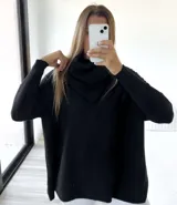 Sweater negro de tejido de punto acanalado, con cuello alto caído y corte mega oversize.