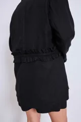 Blazer marrón con solapas de muesca, cierre frontal con lazo y mangas largas. Presenta volados a lo largo de las costuras laterales del pantalón a juego.