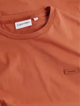 Remera color ladrillo de algodón orgánico, con cuello redondo y logo bordado en el pecho.