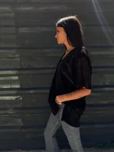 Remera negra con brillo dorado, de mangas cortas y escote en V.