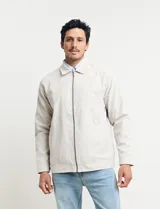 Campera de hombre color beige con cierre frontal, cuello camisero y bolsillos laterales. Corte clásico.