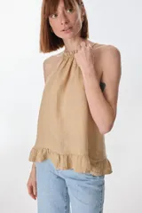 Musculosa color beige de lino, con cuello halter con volados y volados en el ruedo.