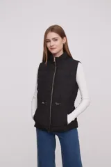 Chaleco negro acolchado sin mangas, con cierre frontal y bolsillos.