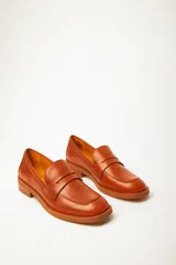 Mocasín estilo preppy de cuero vacuno en color marrón, con detalle de antifaz y taco bajo.