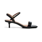 Sandalias negras de charol con tira delgada sobre los dedos y tobillo con hebilla dorada.