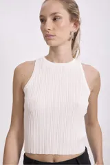 Musculosa negra de tejido de punto acanalado, con cuello redondo y sisas amplias.