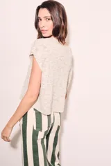Chaleco de punto color beige con cuello redondo y mangas cortas.
