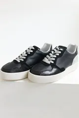 Championes urbanos de cuero color negro con cordones negros y suela blanca. Incluye un par de cordones adicionales de otro color.