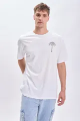 Remera blanca de manga corta con corte oversize y estampa en la espalda con palmeras y texto "Nicoya Peninsula".
