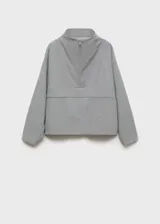 Anorak gris con cuello chimenea, diseño oversize y cierre de cremallera en el cuello.