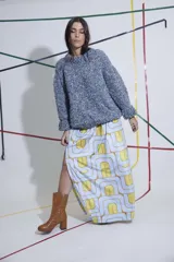 Pollera larga de terciopelo estampado con diseño geométrico en tonos celeste y amarillo. Tiene corte evasé, tajo lateral y cintura elastizada.