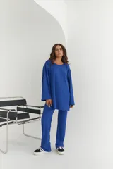 Conjunto verde oliva de punto morley, compuesto por un buzo de corte holgado con mangas largas y aberturas laterales, y un pantalón palazzo de tiro alto.