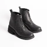 Botas cortas de cuero color marrón con cierre frontal con cremallera, suela de goma y taco bajo.