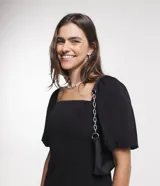Vestido corto negro de viscosa con escote cuadrado, mangas cortas abullonadas, lastex en la espalda y abertura en el bajo.