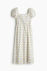 Vestido largo de algodón con estampado floral, escote cuadrado, cuerpo fruncido, mangas cortas abullonadas y falda con leve vuelo.