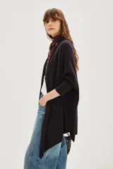 Cárdigan color beige de tejido suave, con calce relajado y largo irregular.