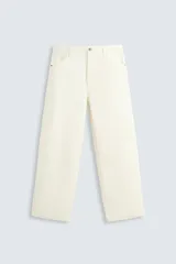 Pantalón de jean color crema, de corte amplio y tiro alto, con cinco bolsillos y cierre frontal con botones.