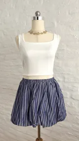 Minifalda globo con cintura elastizada, color azul con rayas verticales blancas.