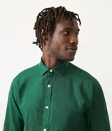 Camisa de lino negra de manga larga, con cuello camisero y abotonadura frontal.