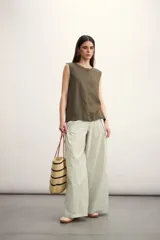 Blusa color crema sin mangas, de lino, con cuello redondo y corte recto.