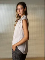 Blusa negra de gasa marca Tahari, con cuello a la base con solapa, abertura central con botones ocultos y detalle plisado en hombros.