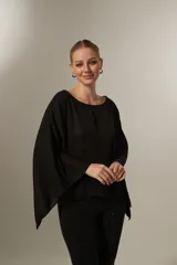 Blusa negra holgada de poliéster con mangas largas y cuello redondo.