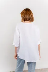 Blusa celeste de lino, con escote en V, manga tres cuartos y botón de madera.