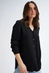 Blusa negra de manga larga con escote en V y cierre frontal con botones.