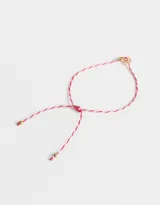 Pulsera de hilo trenzado color rosa y rojo con dije de corazón dorado.