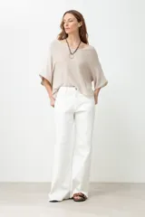 Sweater color beige de tejido de punto, corte amplio y escote en V.