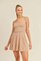 Vestido corto color champagne con breteles finos y falda acampanada.