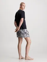 Conjunto de pijama que incluye camiseta de algodón con cuello redondo y logo estampado, y shorts de algodón con bolsillos y cinturilla elástica de Calvin Klein.