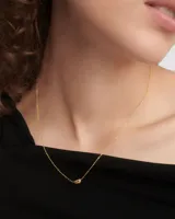 Collar dorado con cadena fina y dije pequeño en forma de lágrima con incrustaciones de circonitas.