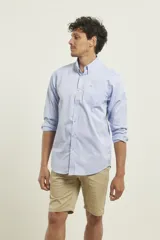 Camisa celeste de manga larga con cuello abotonado, corte clásico y bolsillo en el pecho.