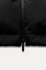 Chaleco largo negro acolchado con cuello alto ajustable con cordones y cierre frontal con cremallera.