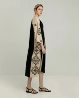 Túnica larga de lino color beige con bordados negros en mangas y ruedo.