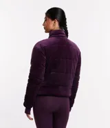 Campera deportiva de terciopelo color violeta, con cuello alto, cierre de botones, bolsillos laterales y puños ajustados.