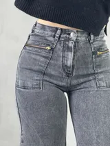 Pantalón de jean gris oscuro, corte wide leg, tiro alto y bolsillos frontales con cierre.