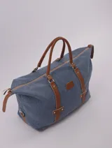 Bolso de viaje negro con detalles en cuero marrón, doble asa de mano y cierre superior con cremallera.