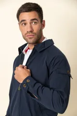 Campera color beige con cierre frontal, cuello camisero, bolsillos laterales y elástico en la cintura. Detalle de bolsillo en la manga izquierda.