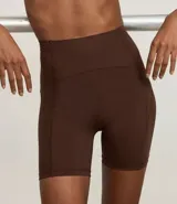 Conjunto deportivo de dos piezas, color fucsia vibrante, compuesto por un top deportivo de escote redondo y una bermuda ciclista de tiro alto.