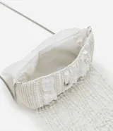 Bolso de fiesta blanco con lentejuelas y flecos de cuentas. Tiene asa de cadena plateada y cierre con botón a presión.