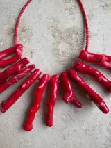 Collar de cuentas rojas con colgantes de coral rojo.